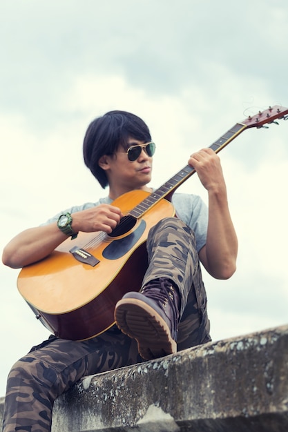 Парень с гитарой, стоящей на плотине, штаны для груза