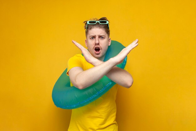 Guy with an inflatable swimming ring on vacation in the summer does not allow with his hands