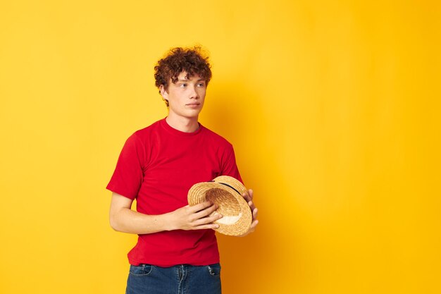 парень с рыжими вьющимися волосами в повседневной одежде шапка позирует на желтом фоне без изменений. Фото высокого качества