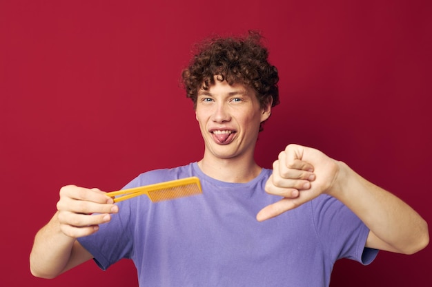 Guy with red curly hair comb hair care posing isolated background