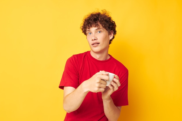 Guy with red curly hair in a red Tshirt with a white cap in his hands isolated background unaltered High quality photo