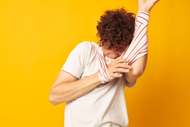 Foto ragazzo con la maglietta a strisce rossa dei capelli ricci che posa l'abbigliamento estivo ha isolato lo sfondo inalterato