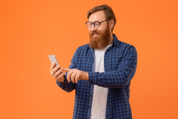 Photo guy with red hair and beard browses on smartphone studio