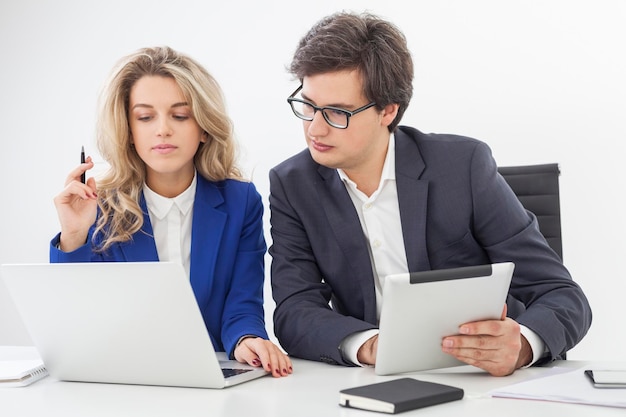 Guy with a tablet looking at notebook screen