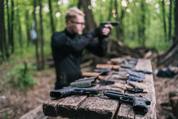 Guy in the woods tests his weapons for shooting sports