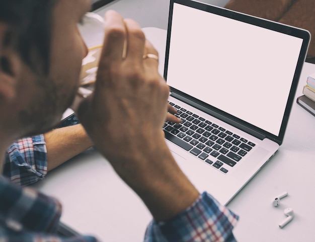 Il ragazzo che lavora con il laptop online da casa.