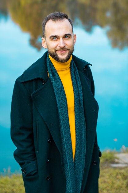 Photo guy in a yellow turtleneck near the lake