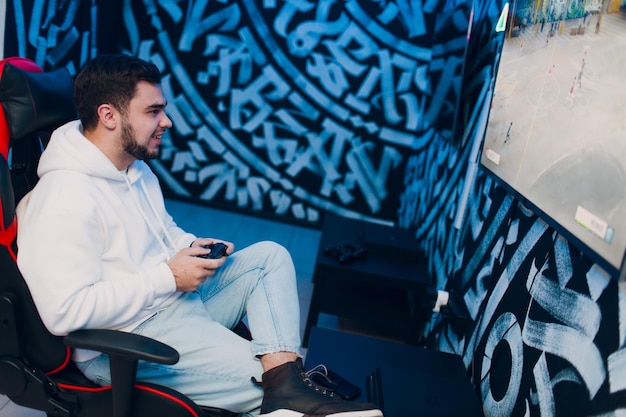 Guy young adult man playing video game on game console at computer gaming club