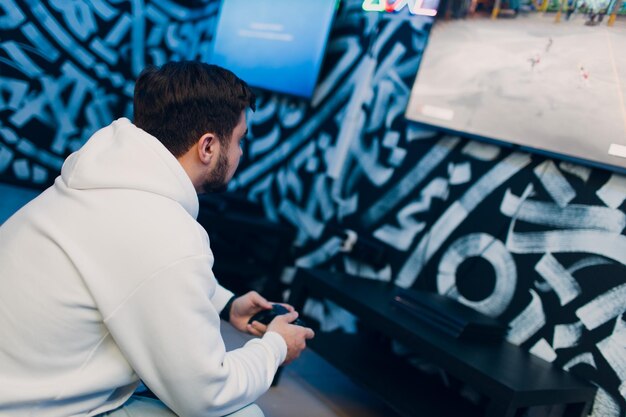 Guy young adult man playing video game on game console at computer gaming club