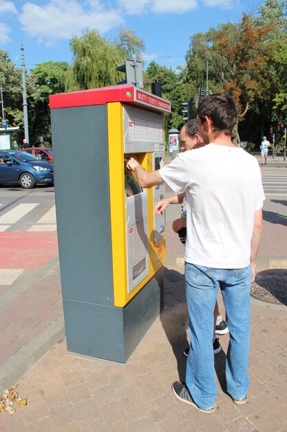 guys buying bus tickets at self service vending machine on stationvacation trip