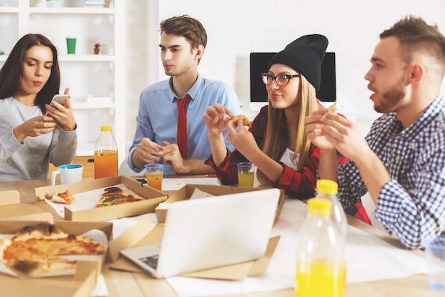 Guys and girls eating at workplace