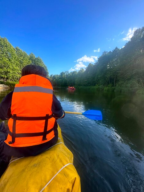 Guys young women and men raft down the river in summer