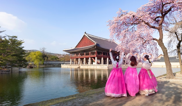 ソウル、韓国の春に韓国の民族衣装と桜の景福宮。