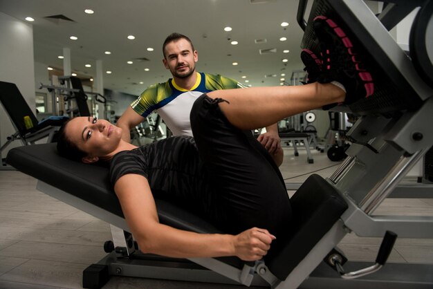 Gym Coach Helping Woman On Legs