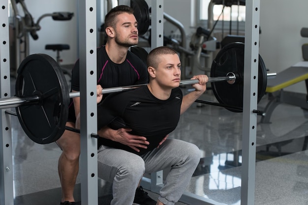 Gym Coach helpt man op Barbell Squat