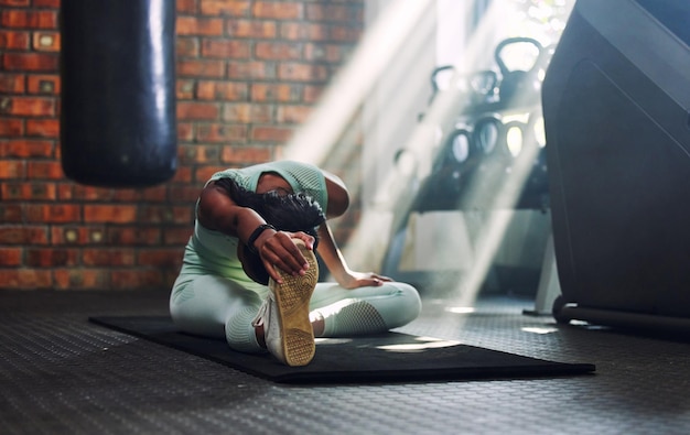 Photo gym fitness or flexible woman stretching legs for a workout or body movement for wellness warm up active athlete or healthy girl relaxing her spine in exercise training for flexibility or mobility