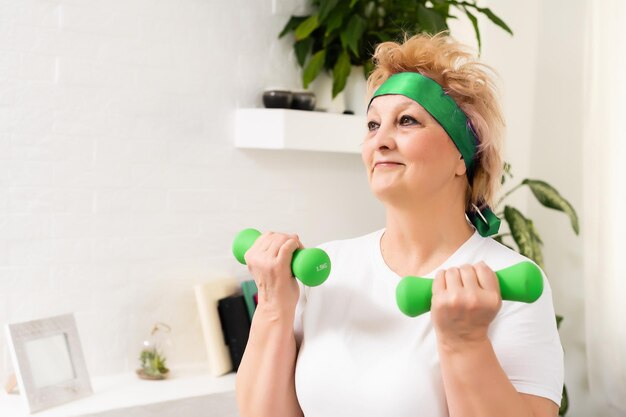 Gym At Home. Positive Aged Woman Training With Dumbbells In Living Room, Copy Space.