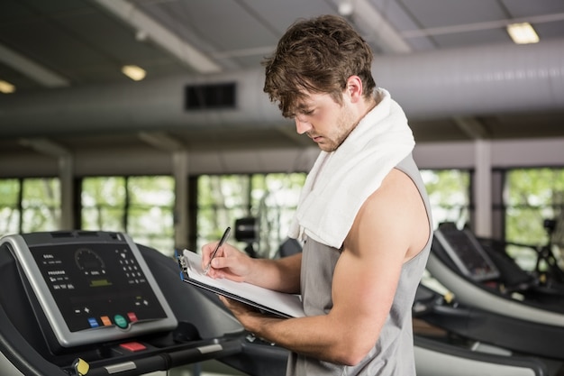 Gym instructor writing on clipboard