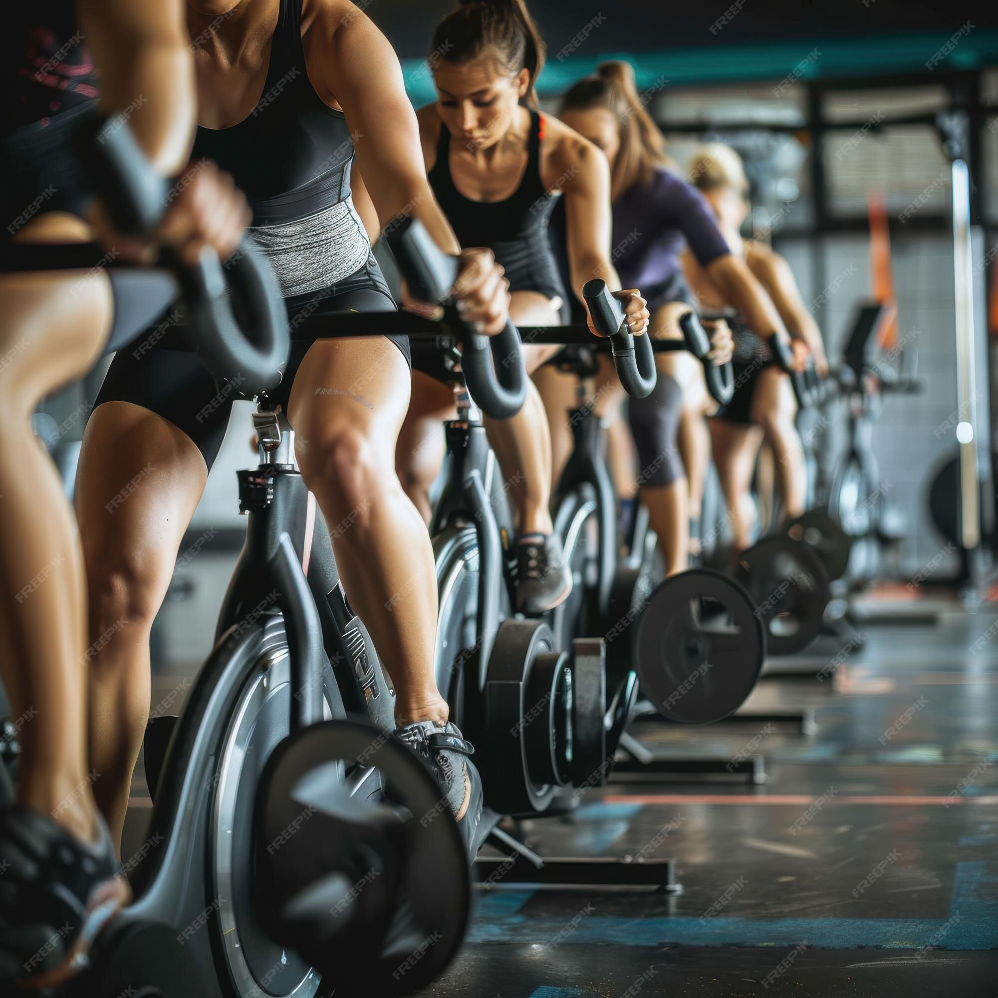 Gym training on stationary bikes Large group of athletic people having
