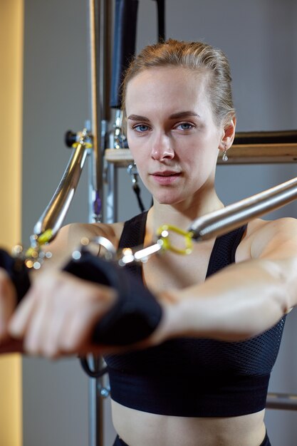 Gym vrouw pilates uitrekkende sport in hervormer bed instructeur meisje.