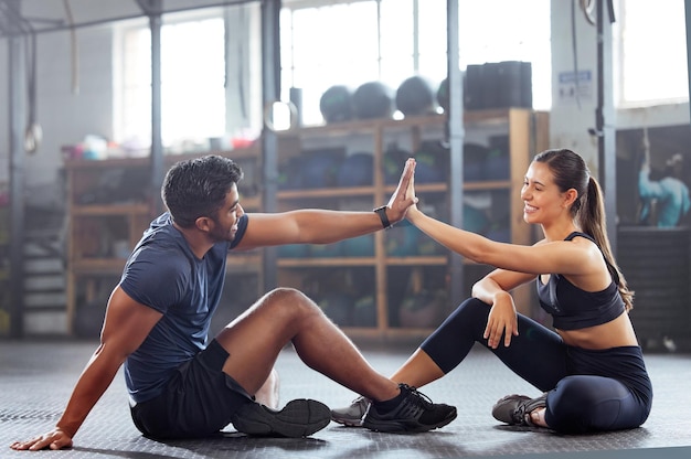 Gym wellness-paar high five voor succes of goede oefening en goed gedaan gebaar voor het bereiken van fitnessdoel Actieve trainer en klantvrouw die een geweldige trainingstraining of trainingssessie vieren