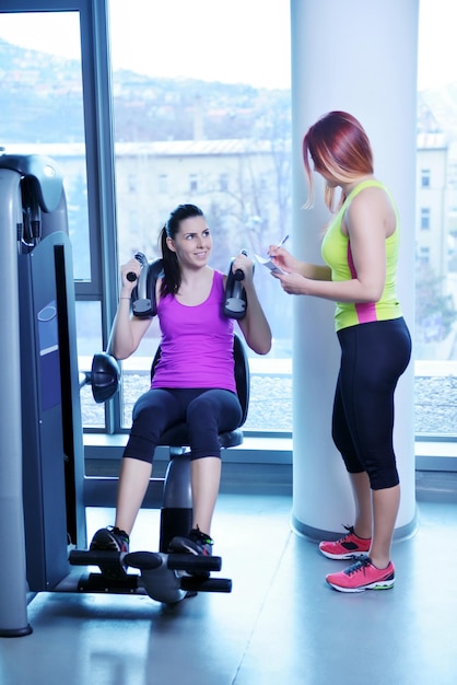 Gym woman exercising with her personal trainer