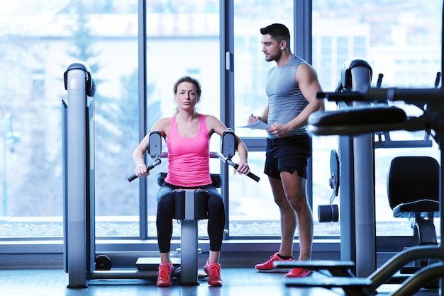 Gym woman exercising with her personal trainer