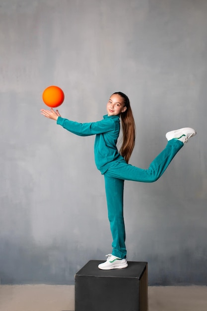 The gymnast raises her leg high good stretching gymnast pulls a sock gymnast with a ball