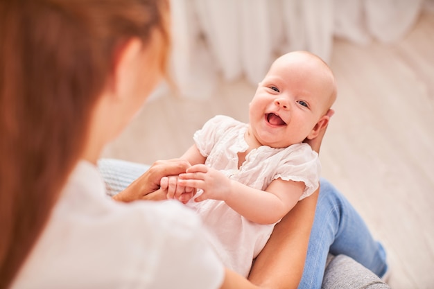 Foto gymnastiek baby. vrouw die oefeningen met baby voor zijn ontwikkeling doet. masseer een kleine pasgeboren baby.