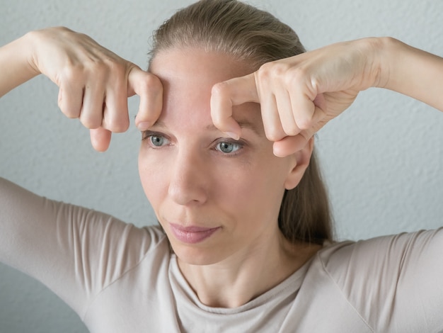 Gymnastiek voor het gezicht. Vrouw doet verjongende oefeningen voor het gezicht