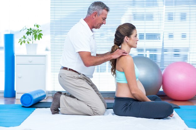 Gymnastiektrainer die zwangere vrouw masseren