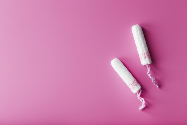 gynecological tampons on a pink background top view, free space