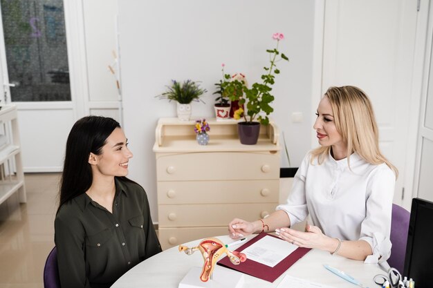 Gynecologist asks young girl about menstrual cycle and writes down information in the questionnaire Consultation with gynecologist and discussion of reproductive health of woman in gynecology clinic