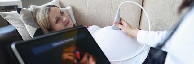 Foto il ginecologo conduce l'ecografia della donna incinta a casa