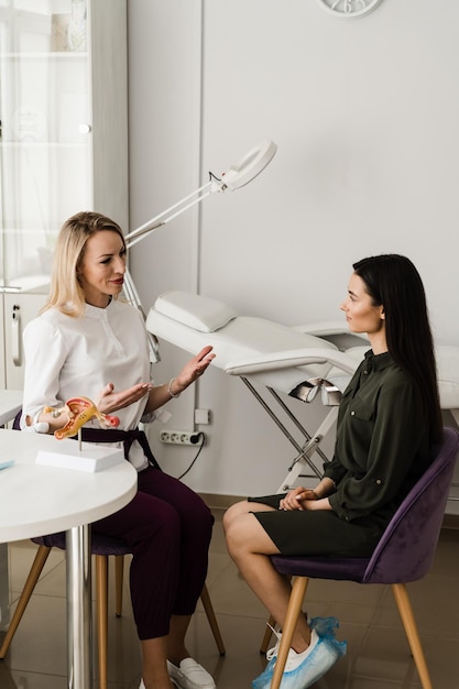 Gynecologist consultation about complaints gynecological history previous or current diseases of reproductive system Gynecologist explains uterus structure on the example of model