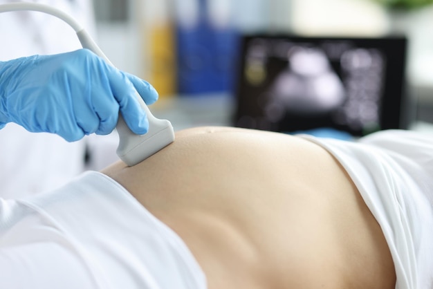 Gynecologist doing ultrasound scan on belly pregnancy screening