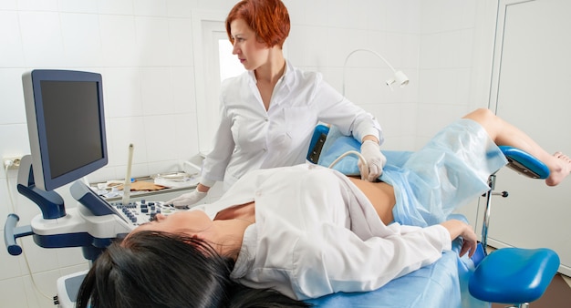 Gynecologist doing ultrasound scanning for pregnant woman