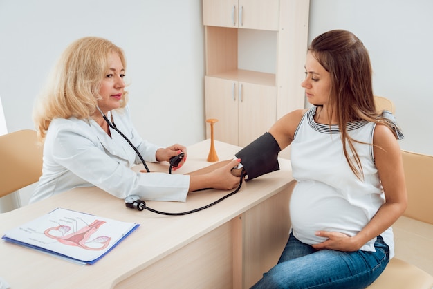 A gynecologist examines a pregnant woman.