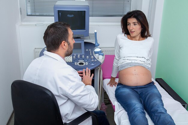 Photo gynecologist talks to the pregnant woman