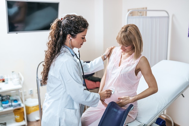 Gynecology examination and consultation. Pregnant woman with her doctor at clinic.