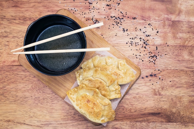 Gyoza dumplings with fish on a wooden board