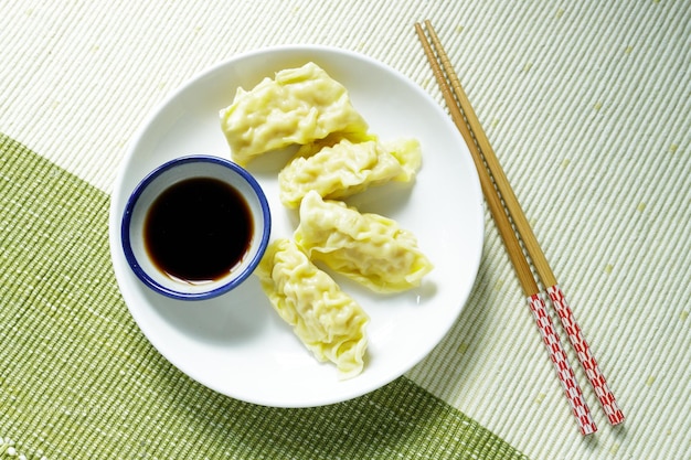 Foto il gyoza con salsa viene posto su un piatto bianco.