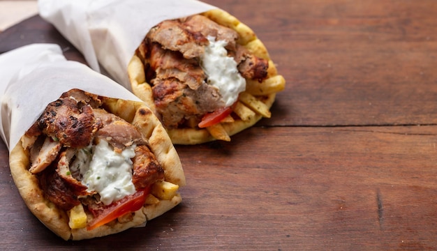 Foto gyro pita shawarma porta via il cibo di strada cibo tradizionale greco turco a base di carne su tavola di legno