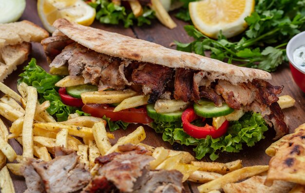 Gyros shoarma om straatvoedsel mee te nemen Sandwich met vlees op houten tafel