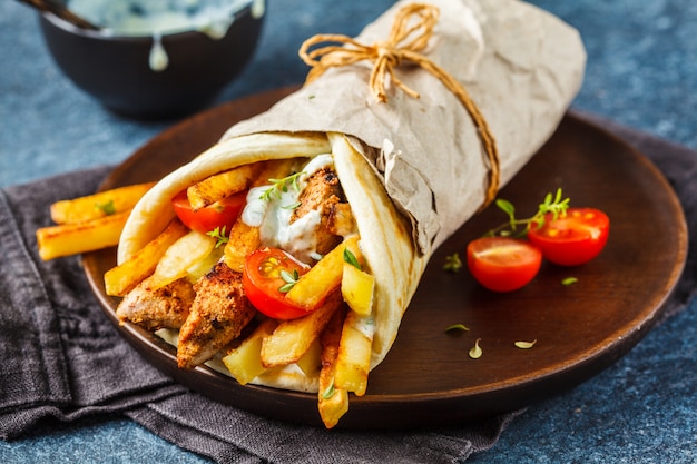 Gyros souvlaki wraps in pita bread with chicken, potatoes and tzatziki sauce.