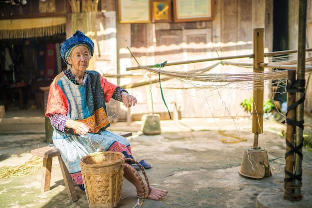 Photo ha giang vietnam aug 12 2023 hmong ethnic artisans are spinning flax to weave brocade this is a traditional craft handed down for a long time hmong minority people working and smiling