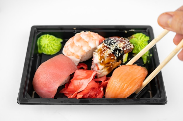 Haal sushi weg in een plastic bakje, roze gember, wasabi. sushi levering concept