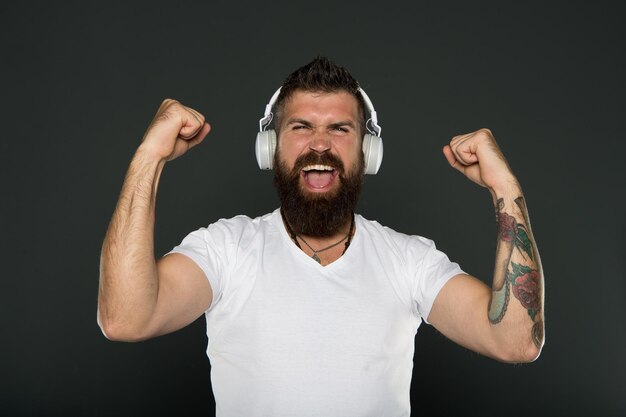 Haar baard zorg Mannelijke kapper zorg Bebaarde man Zelfverzekerde en knappe brutale man Rijpe hipster met baard gelukkig man succes hipster in hoofdtelefoon uitdrukken muziekliefhebber online blijven mannelijke schoonheid