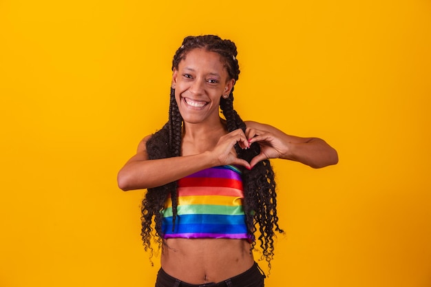 Haar jonge vrouw met dreadlocks en lesbische vlechten. Door haarzelf. Mooie en gelukkige afro jonge vrouw met het symbool van mensenrechten Lgbt, gelijkheid, Lgbt. Lesbiennes maken een hart met de hand