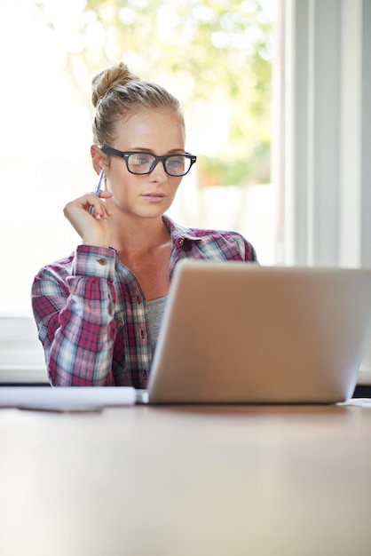 Haar kennis bijspijkeren met een online cursus Shot van een jonge vrouw die thuis werkt